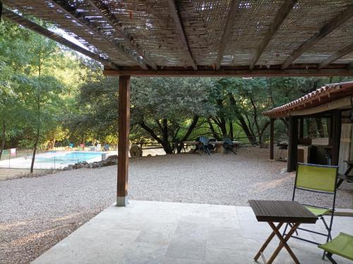 un pavillon avec une table et un banc et une piscine dans l'établissement Un Coin Paradis ds Campagne 12 hect PISCINE privée, à Méounes-lès-Montrieux