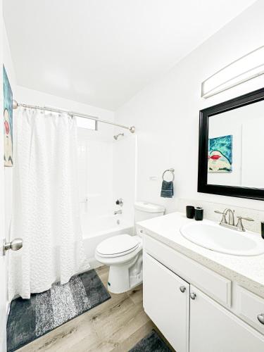 a white bathroom with a toilet and a sink at Charming 2-BR, 2-Story Retreat in Heart of LA - BR4 in Los Angeles