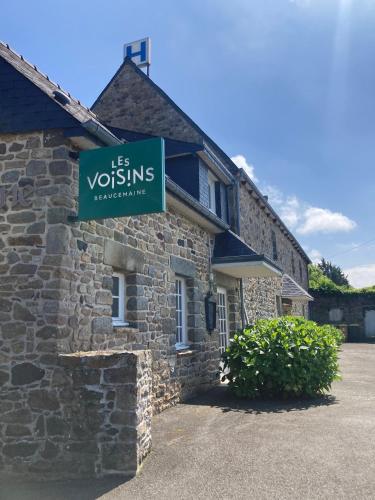 a sign on the side of a stone building at Hôtel Les Voisins Beaucemaine in Ploufragan