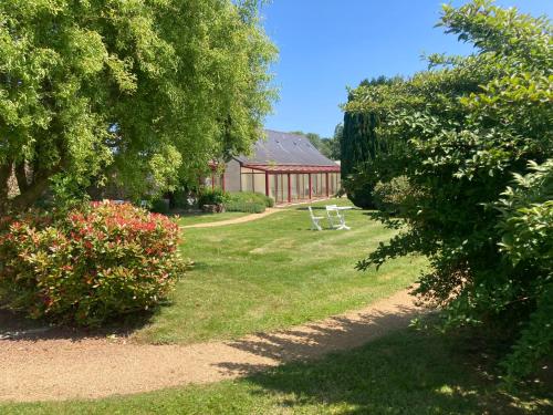 a garden with a picnic table and a building at Hôtel Les Voisins Beaucemaine in Ploufragan