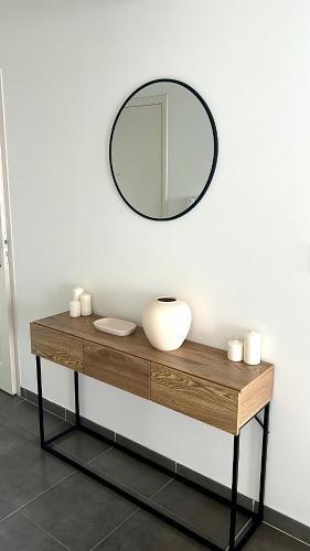 un miroir assis au-dessus d'une table en bois dans l'établissement Charmant Studio proche de Genève, à Saint-Julien-en-Genevois