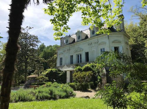 une grande maison blanche au milieu d'une cour dans l'établissement Chateau La Palue, à Coutras