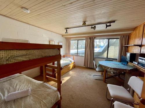 een slaapkamer met 2 stapelbedden, een bureau en een tafel bij Rocky Valley 11 in Falls Creek