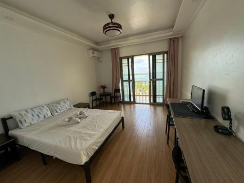 a room with a bed and a desk with a laptop at Pango Ocean Blue Hotel in Port Vila
