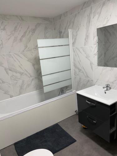 a bathroom with a sink and a mirror at Duplex neuf cosy centre Seclin in Seclin