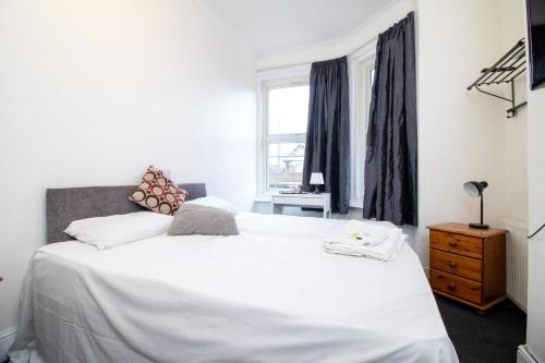 a bedroom with a white bed and a window at Pebbles guest house room 6 in Southampton