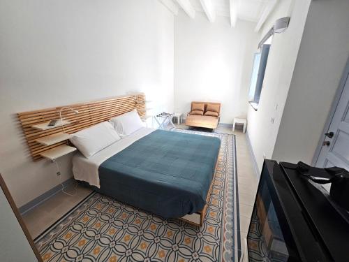 Un dormitorio con una cama y una silla en una habitación. en Rosa Dei Venti Guest House, en Cabras