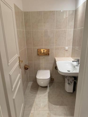 a small bathroom with a toilet and a sink at Maisonette Dachterrasse Golfplatz in Michendorf