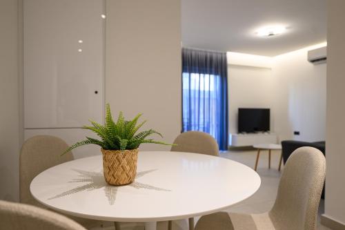 a white table with a plant on it in a room at Hidden Gem by the Sea in Artemida