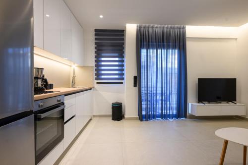 a kitchen with a large window and a television at Hidden Gem by the Sea in Artemida