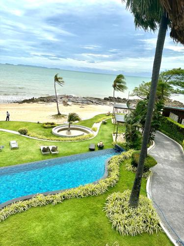 a resort with a swimming pool next to the beach at The Palm Wongamat 22 in North Pattaya