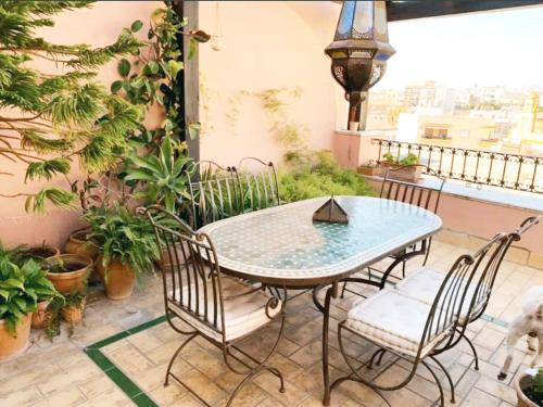 a patio with a table and chairs on a balcony at Ático la Estrella in Alcalá de Guadaira