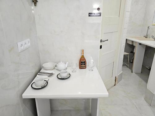 a white table with a bottle of wine and glasses at Center Studio in Chişinău