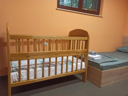 a wooden crib in a room with a bed at BOGO Apartment in Bitola