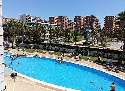 a large swimming pool with people in a city at Apartamento en Marina Trébol III, centro de Mágic World in Oropesa del Mar
