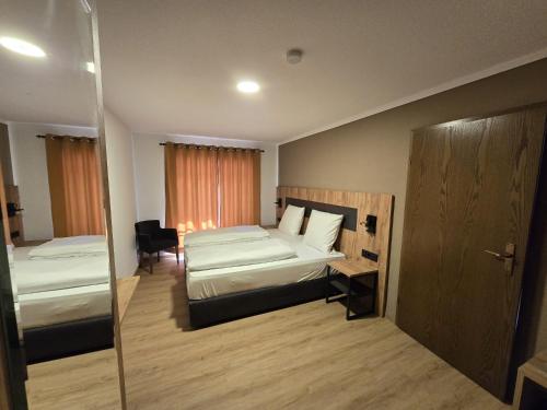 a hotel room with two beds and a mirror at Landgasthof Kreuz mit Gästehaus in Immendingen