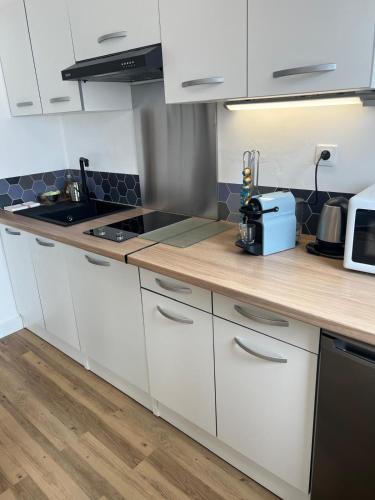 une cuisine avec des armoires blanches et un comptoir en bois dans l'établissement Volt Air Roof Top - Wifi - Parking privé - Proche Gare, à Troyes