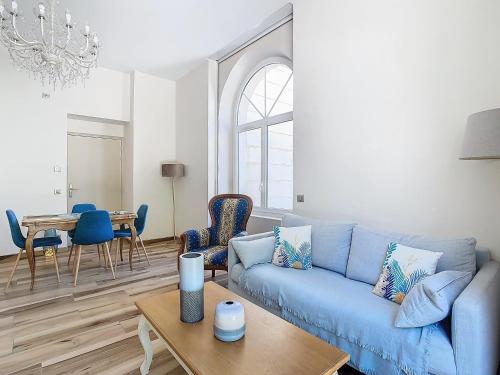 un salon avec un canapé bleu et une table dans l'établissement Villa Bagatelle, à Saint-Laurent-du-Pont