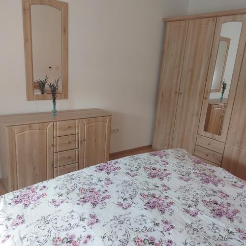a bedroom with a bed and two dressers and a mirror at Gut Sonnenhof in Žatec