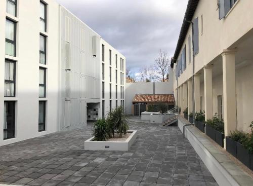 une cour d'un bâtiment avec quelques plantes dans l'établissement Studio équipe au centre-ville de Montpellier, à Montpellier