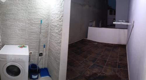 baño con lavadora y suelo de baldosa. en Sarchal, en Ceuta