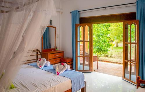 two people are laying on a bed in a bedroom at Sigiriya Cottage in Sigiriya