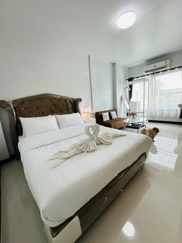 a bedroom with a large bed with a dog sitting on it at Service apartment lampang Room202 ใจกลางเมืองใกล้กาดกองต้า in Lampang