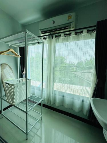 a bathroom with a chair in front of a window at Service apartment lampang Room202 ใจกลางเมืองใกล้กาดกองต้า in Lampang