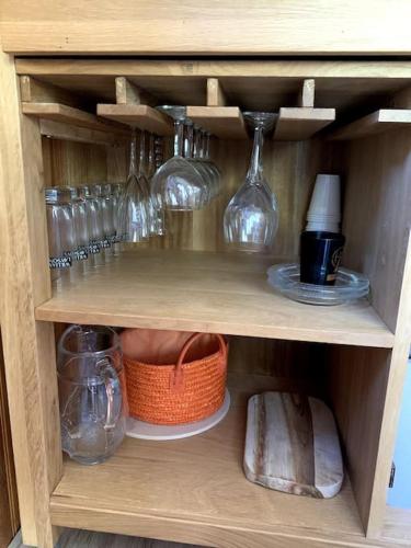 une armoire en bois avec des verres et un panier dans l'établissement Studio avec chambre à Sommand, à Mieussy
