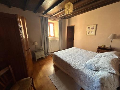 a bedroom with a bed and a window at Gite de l'Elevage de la Mûre in Saint-Just-Saint-Rambert