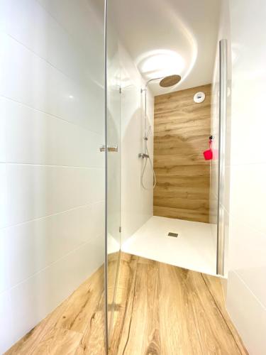 une salle de bain avec une douche avec une porte vitrée dans l'établissement Ty COSY, à Ploemeur