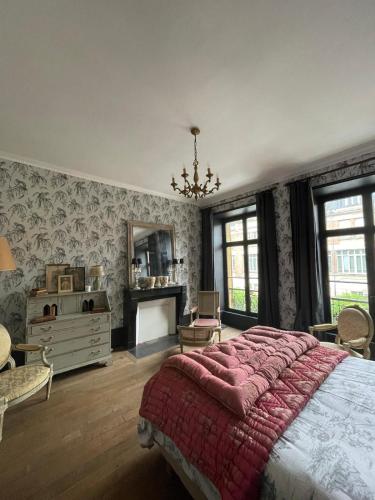 une chambre avec un grand lit et un miroir dans l'établissement Ardennes Manoir Blossom, à Vouziers