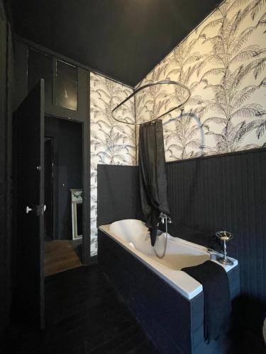 une salle de bain avec une baignoire et un lavabo dans l'établissement Ardennes Manoir Blossom, à Vouziers