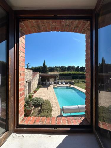 a view of a swimming pool through a window at Gite de l'Elevage de la Mûre in Saint-Just-Saint-Rambert