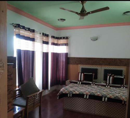 a bedroom with a bed and a ceiling fan at Dolma Guest House Ladakh by LexStays in Leh