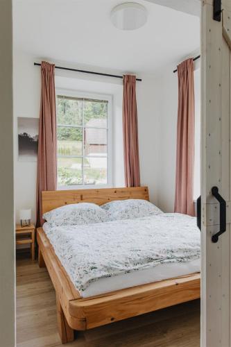 a bedroom with a wooden bed with a window at Chalupa Bezvětří in Malá Morávka