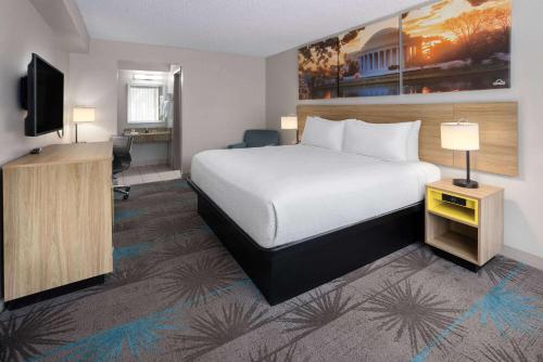 a hotel room with a bed and a television at Days Inn of Frederick by Wyndham in Frederick