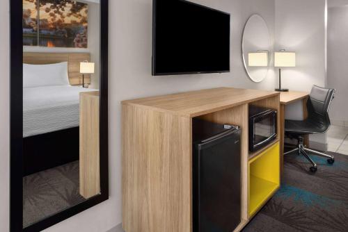 a room with a desk with a television and a bed at Days Inn of Frederick by Wyndham in Frederick
