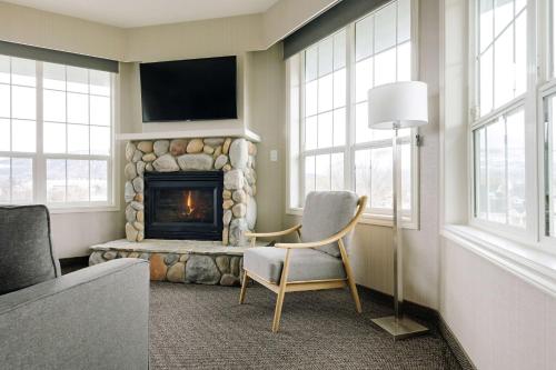 a living room with a chair and a fireplace at Balcomo, a Ramada by Wyndham in Penticton