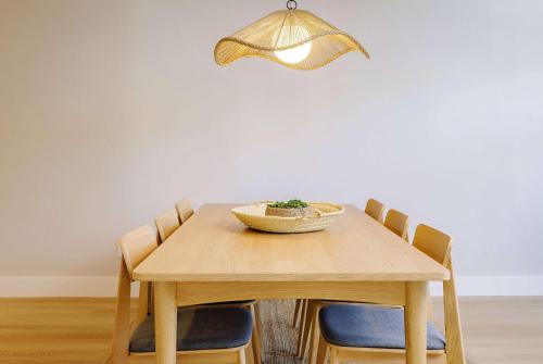 a wooden table with chairs and a bowl on top at Balcomo, a Ramada by Wyndham in Penticton