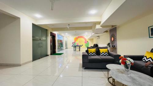 a large living room with couches and a table at BluO Studio5 Golf Course Road - Gym, Terrace Garden in Gurgaon