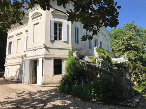 un grand bâtiment blanc avec un escalier devant dans l'établissement Chateau La Palue, à Coutras