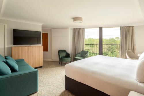 a hotel room with a bed and a flat screen tv at Hilton Birmingham Metropole Hotel in Bickenhill