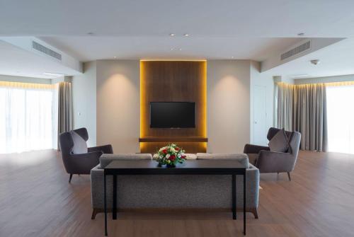 a living room with a couch and chairs and a tv at DoubleTree Resort by Hilton Hotel Penang in Batu Ferringhi
