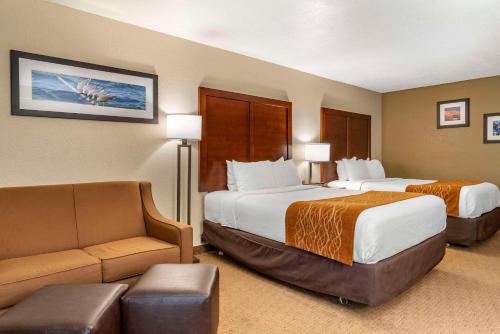 a hotel room with two beds and a couch at Comfort Inn & Suites Lincoln City in Lincoln City