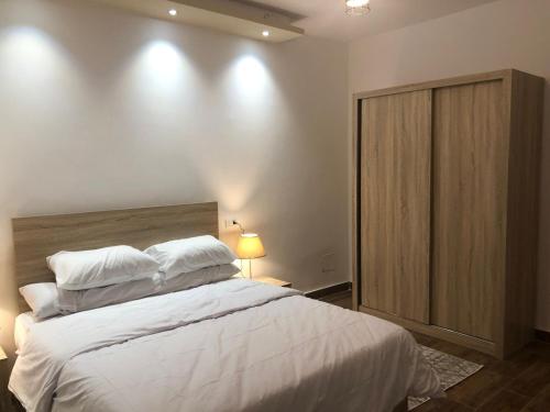 a bedroom with a large bed with white sheets and pillows at Al-Andalos Studio in New cairo