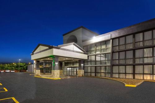 a building with a parking lot in front of it at Wingate by Wyndham Kansas City in Kansas City