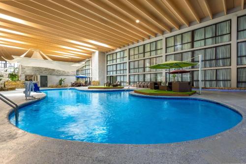 a large swimming pool in a hotel lobby at Wingate by Wyndham Kansas City in Kansas City