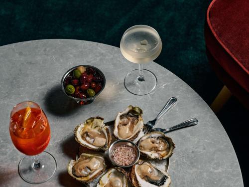 a plate of oysters and a drink on a table at ibis Styles Melbourne Airport in Melbourne