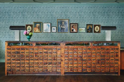 a wooden cabinet with many pictures on a wall at Graduate by Hilton Charlottesville in Charlottesville